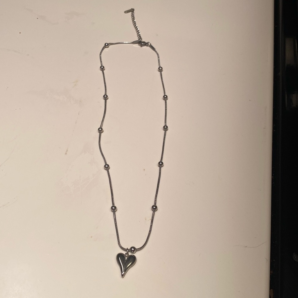 Heart shaped necklace in stainless steel w/snake chain.  New in mesh jewelry bag